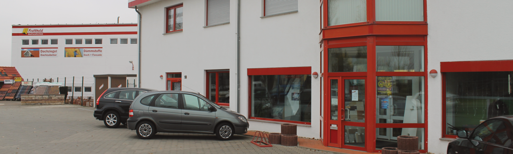 Zwei Autos auf den Parkplätzen vor dem Eingang des Firmengebäudes in Bernburg