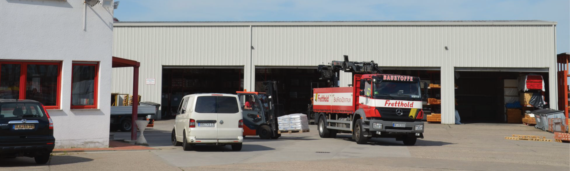 Ein LKW vor einer Lagerhalle, der mit einem Gabelstapler beladen wird